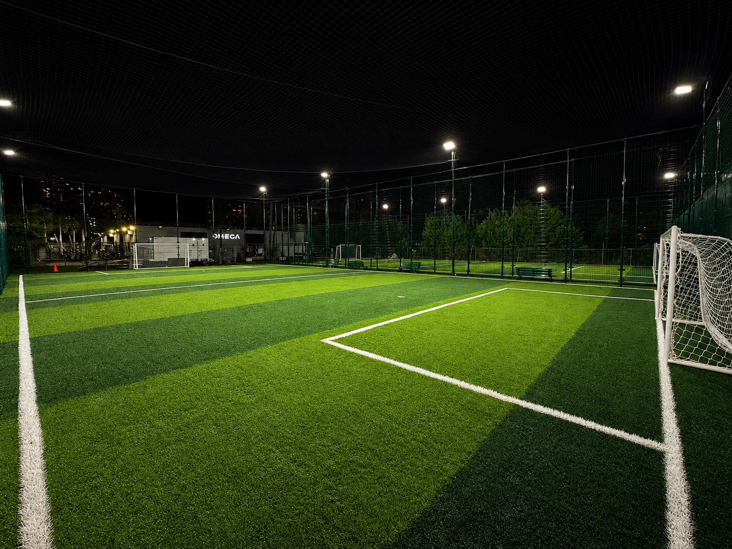 Night turf field at 74 Soccer, floodlights over a 6v6 pitch with a white goal